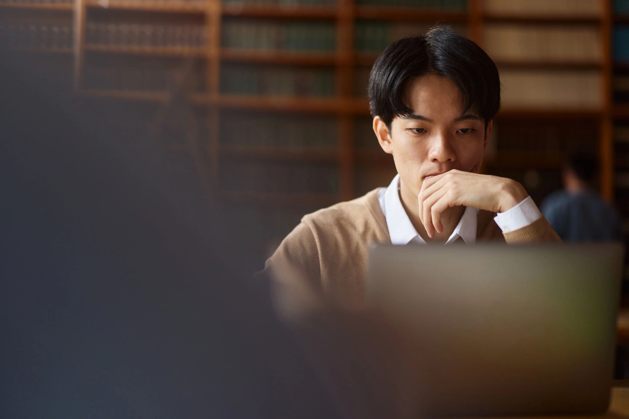 Student studying with a laptop in a library